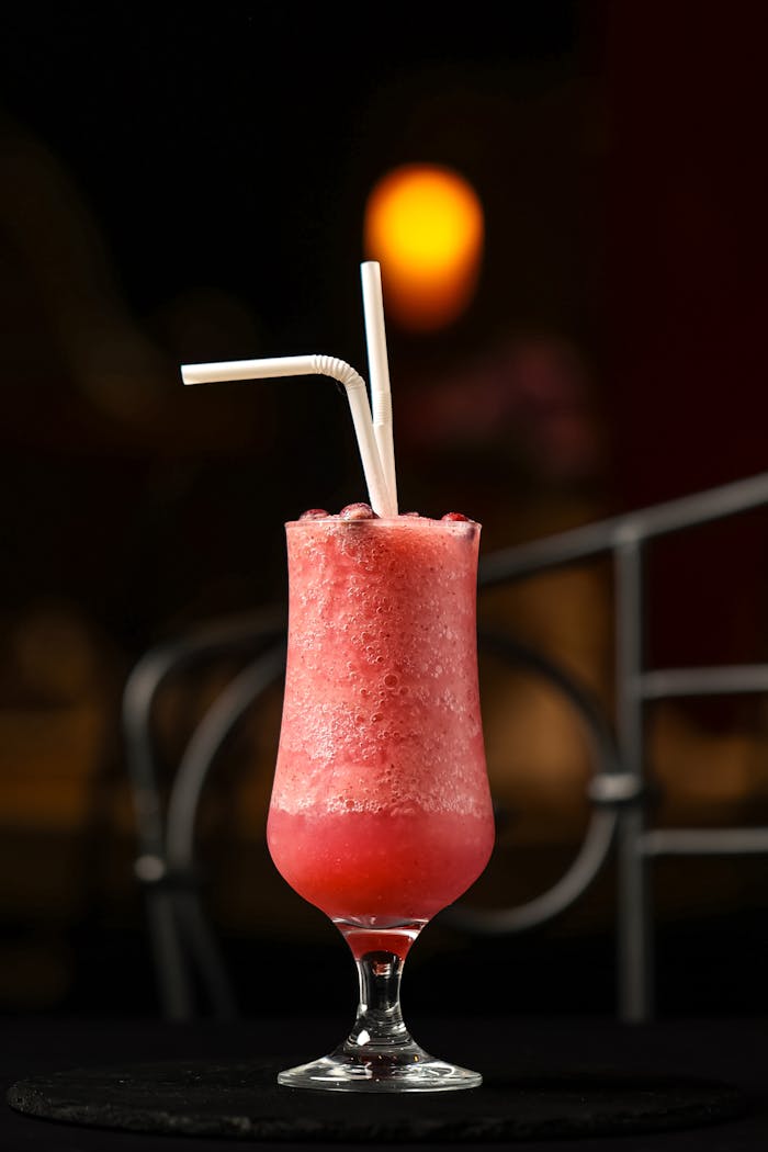footer-cta Chilled red fruit smoothie in a decorative glass with double straws, perfect for a healthy treat.