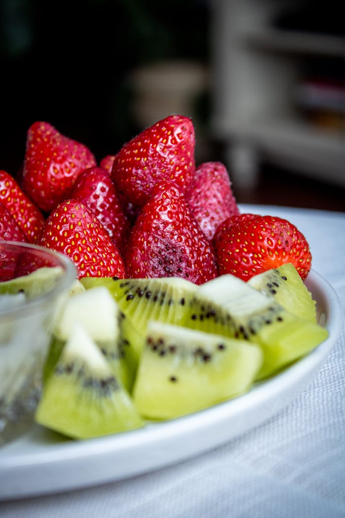 A vibrant platter of fresh strawberries and kiwi slices, perfect for a healthy snack.