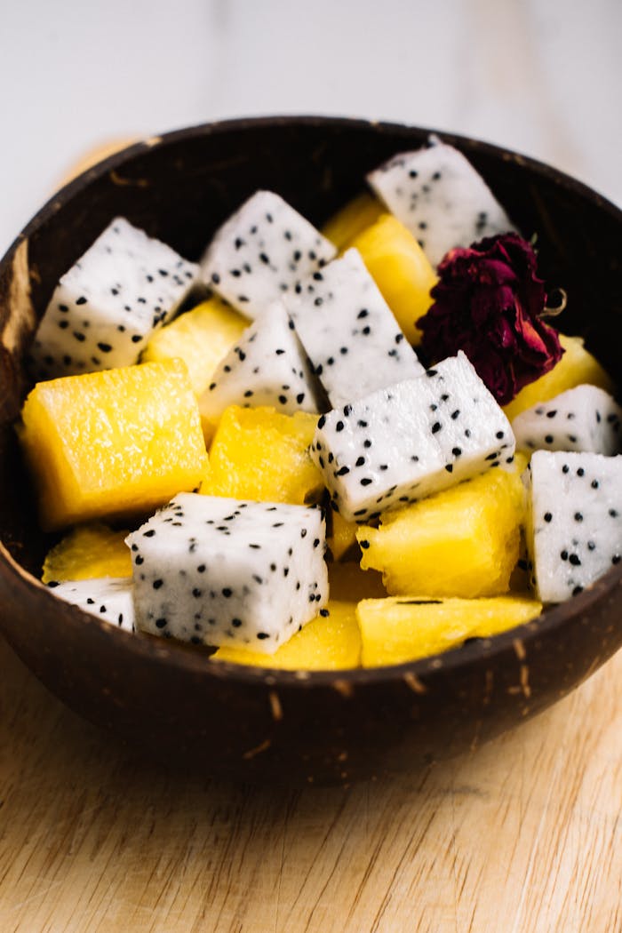 Close-up of a fresh tropical fruit bowl featuring dragon fruit and pineapple cubes.
