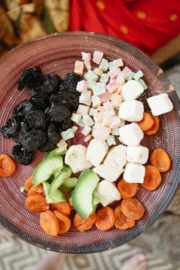 A vibrant plate featuring a mix of dried fruits and colorful candies, perfect as a sweet snack.
